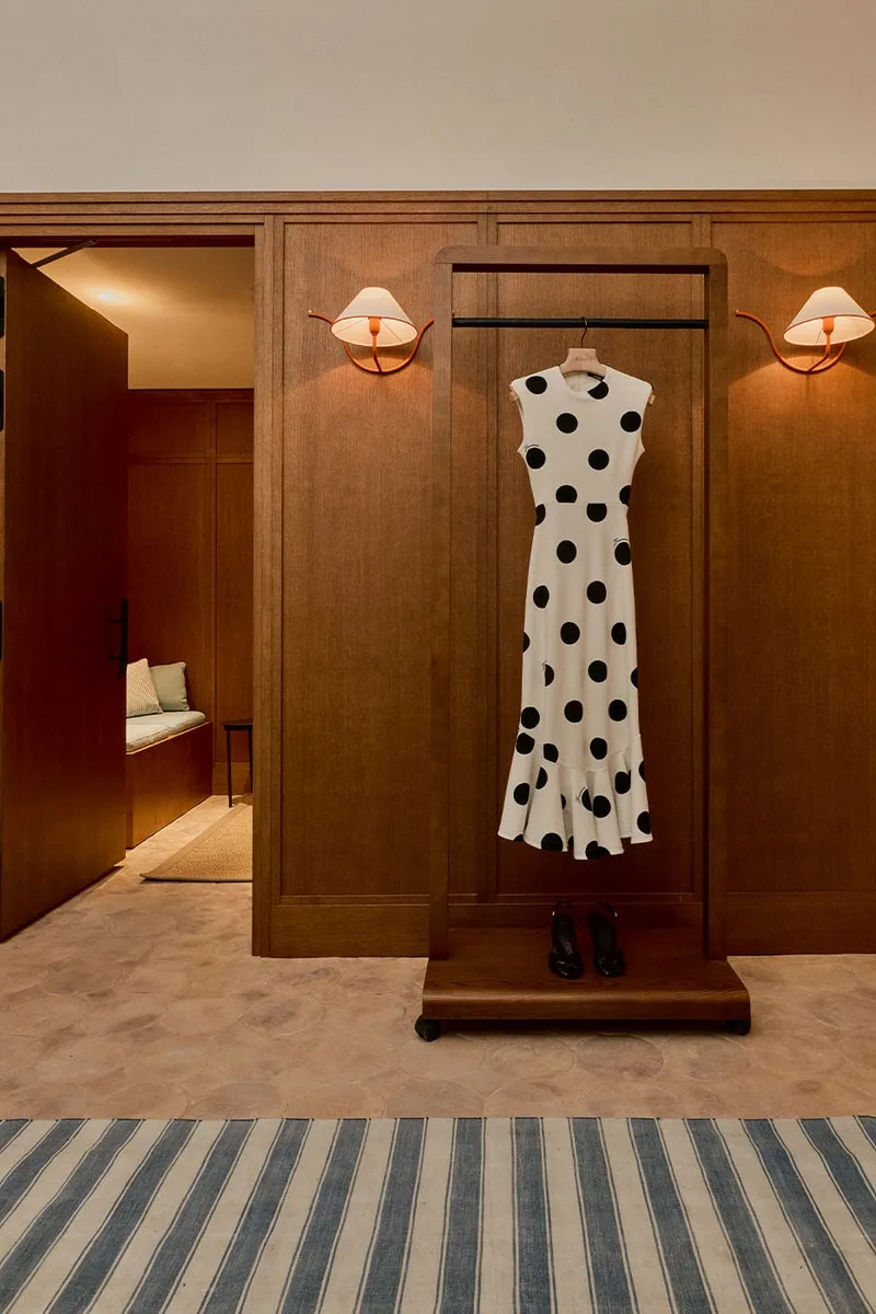 Robe à pois noirs suspendue dans une pièce en bois.
