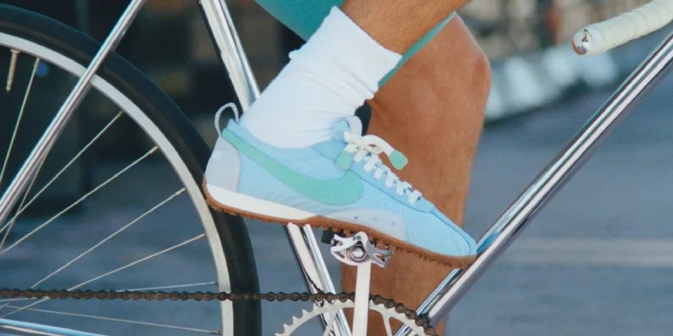 Un pied portant une chaussure bleue et blanche sur une pédale de vélo.