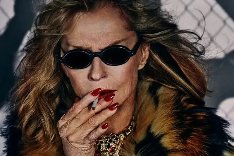 Personne âgée en lunettes fumant, vêtue de fourrure et bijoux.