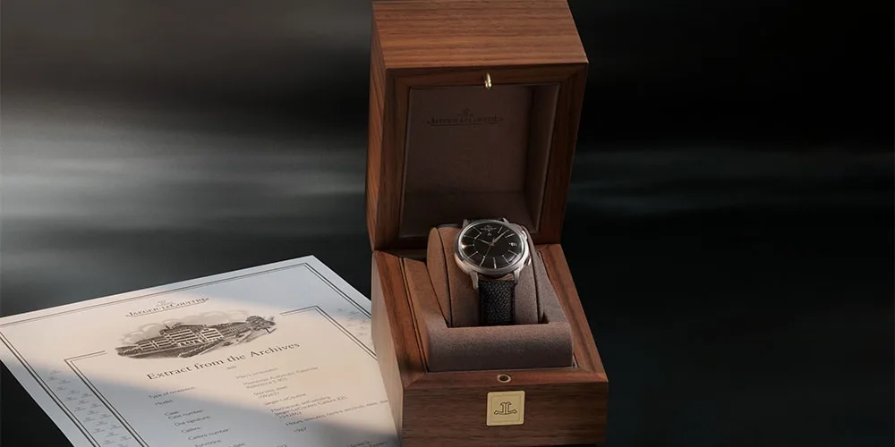 Montre dans coffret en bois avec document, décor élégant et sombre.