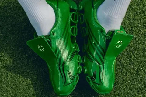 Chaussures de football vertes brillantes sur gazon.