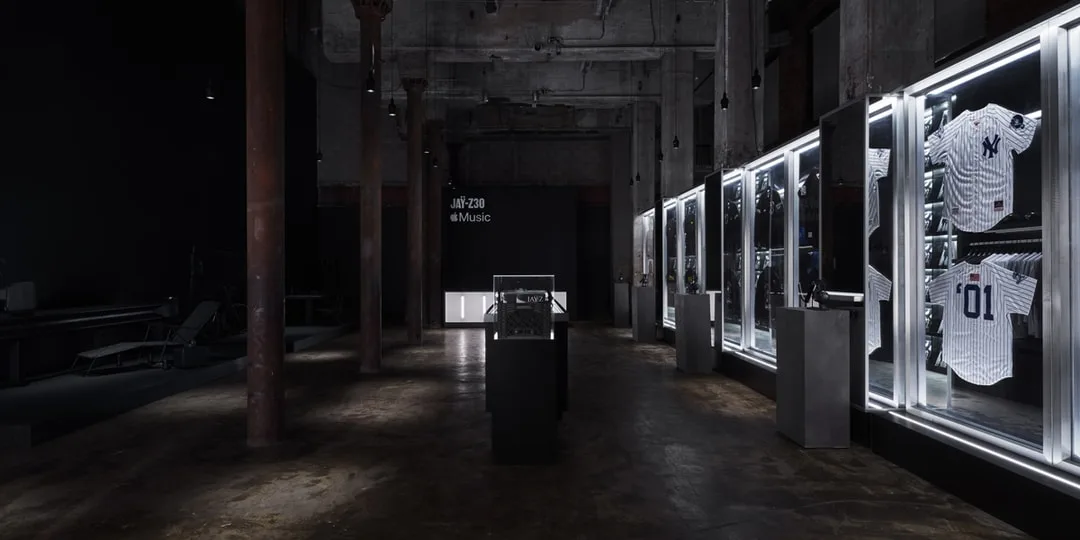 Salle d'exposition avec maillots de sport sous verre illuminé.