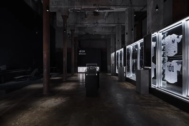 Intérieur industriel avec maillots exposés sous vitrines éclairées.