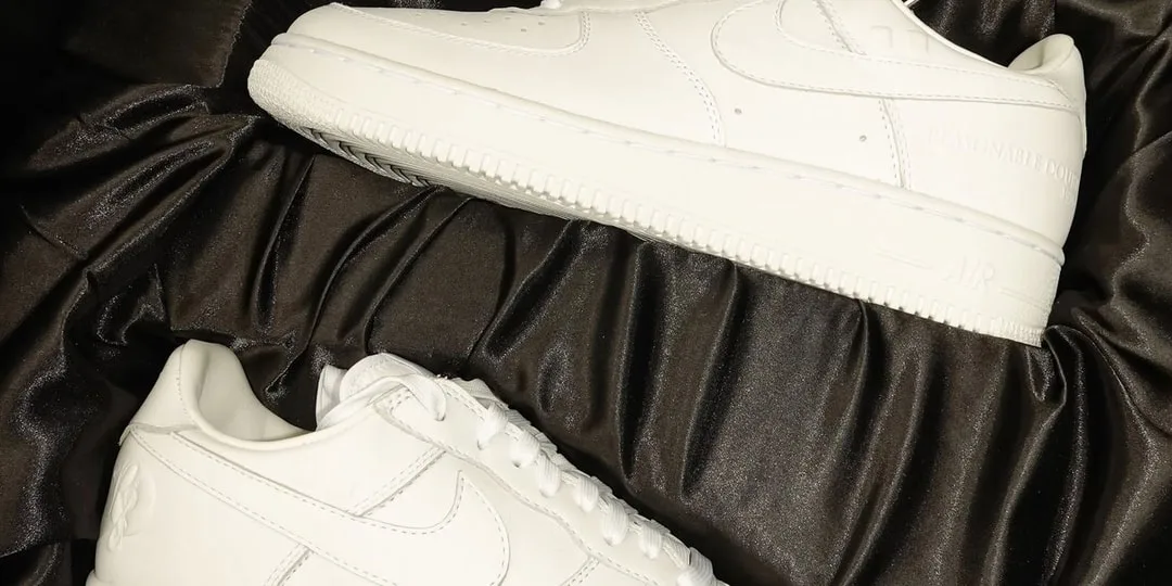 Deux baskets blanches sur un tissu noir.