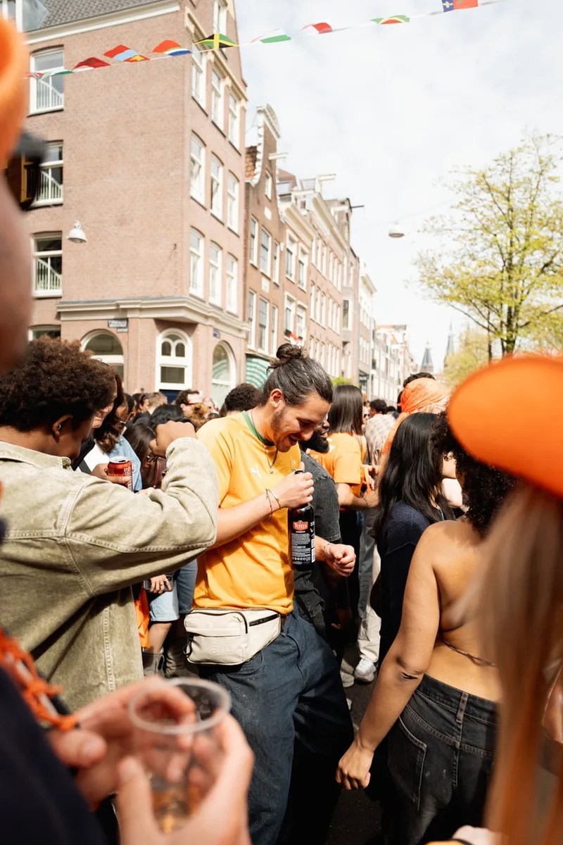 Fête de rue animée avec des gens en vêtements orange.