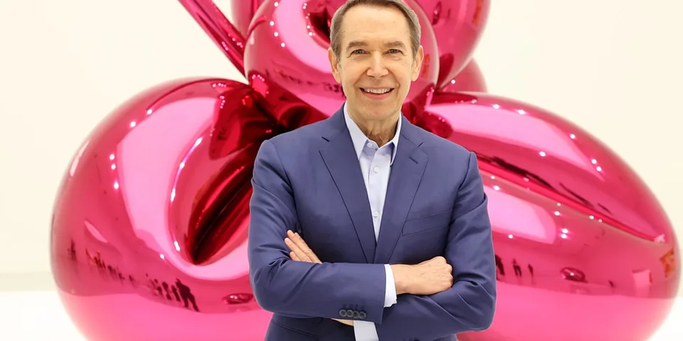 Homme en costume devant une sculpture rose brillante.