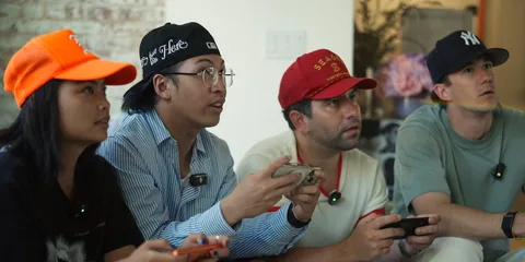 Quatre personnes jouant à un jeu vidéo sur un canapé.