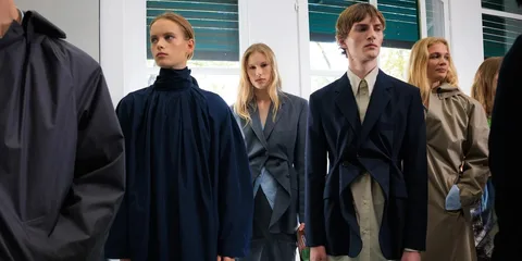 Personnes en vêtements mode attendant dans une rangée.