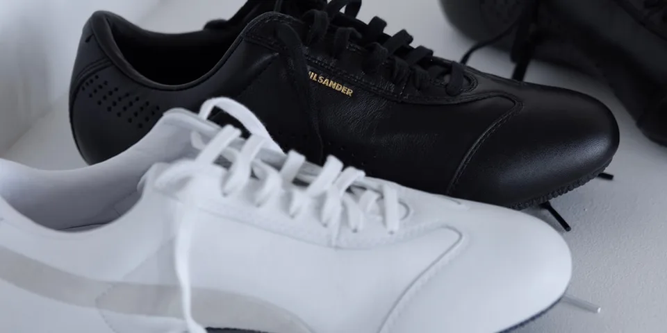 Chaussures noires et blanches sur une surface blanche.