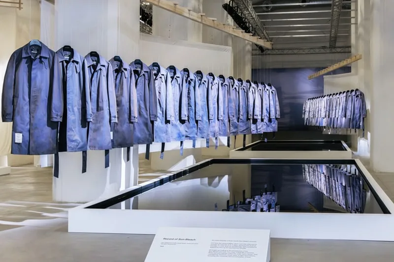 Rangée de manteaux bleus accrochés dans une galerie moderne