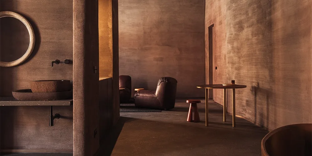 Intérieur moderne brun avec fauteuils et table ronde.