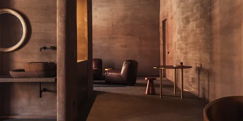 Intérieur moderne brun avec fauteuils et table ronde.