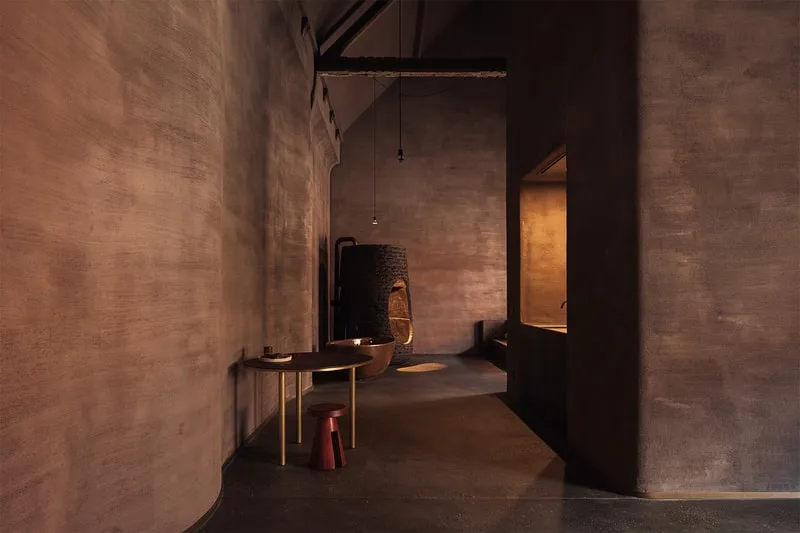 Intérieur sombre avec table et chaise minimalistes.