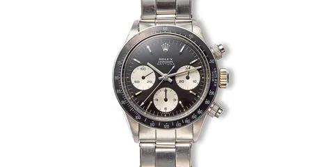 Montre chronographe vintage avec cadran noir et bracelet en métal.
