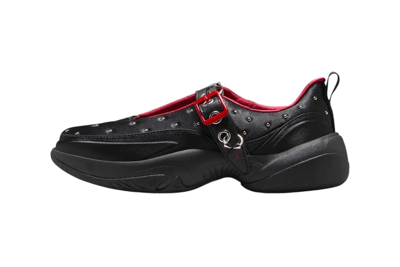 Chaussure noire et rouge avec boucle et détails métalliques.