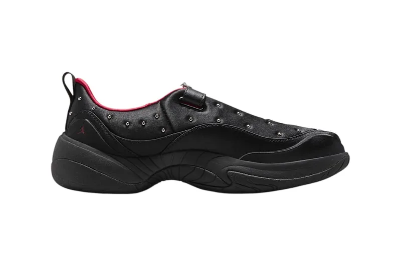 Chaussure noire avec détails rouges et semelle épaisse.