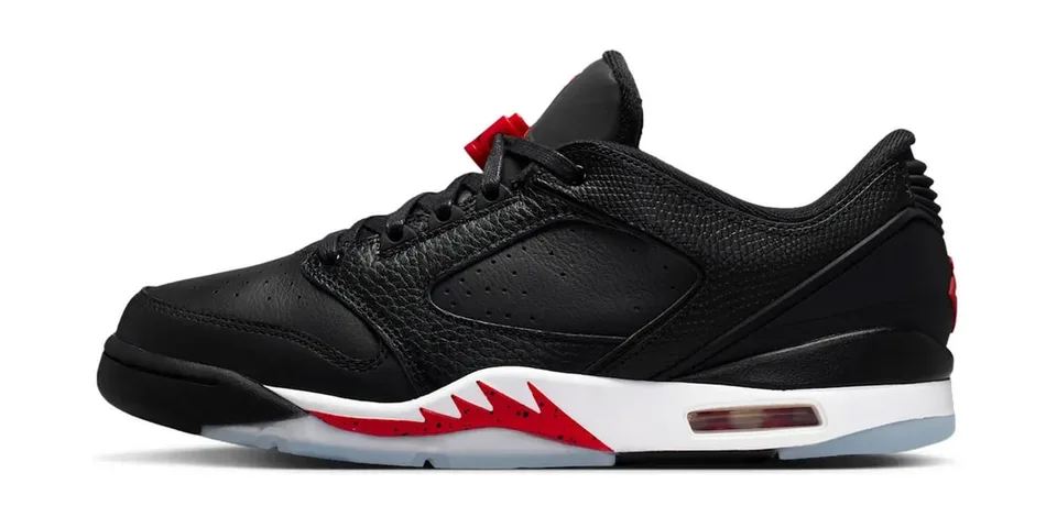 Chaussure de sport noire et rouge avec semelle claire.