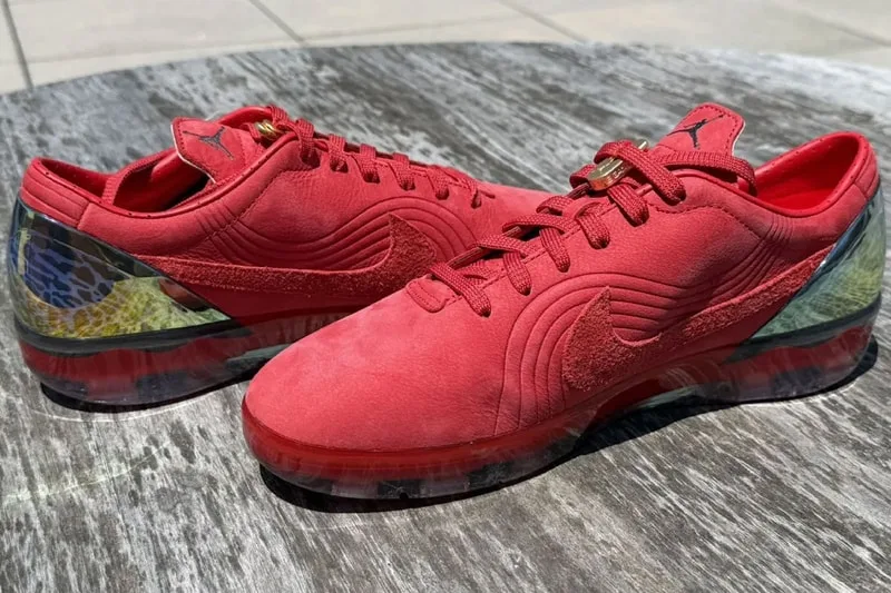 Chaussures rouges avec semelles transparentes et détails colorés sur le talon.