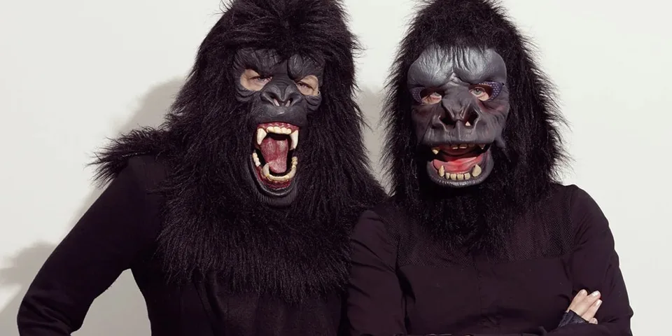 Deux personnes portant des masques de gorille avec des expressions féroces.