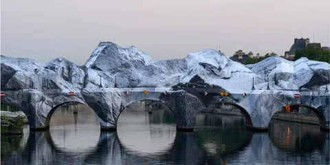 Pont enjambant une rivière avec montagnes peintes sur ses arches.