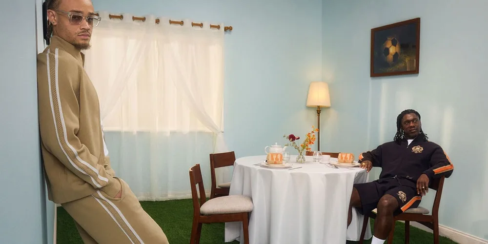 Deux hommes posant dans une pièce avec table et chaise.