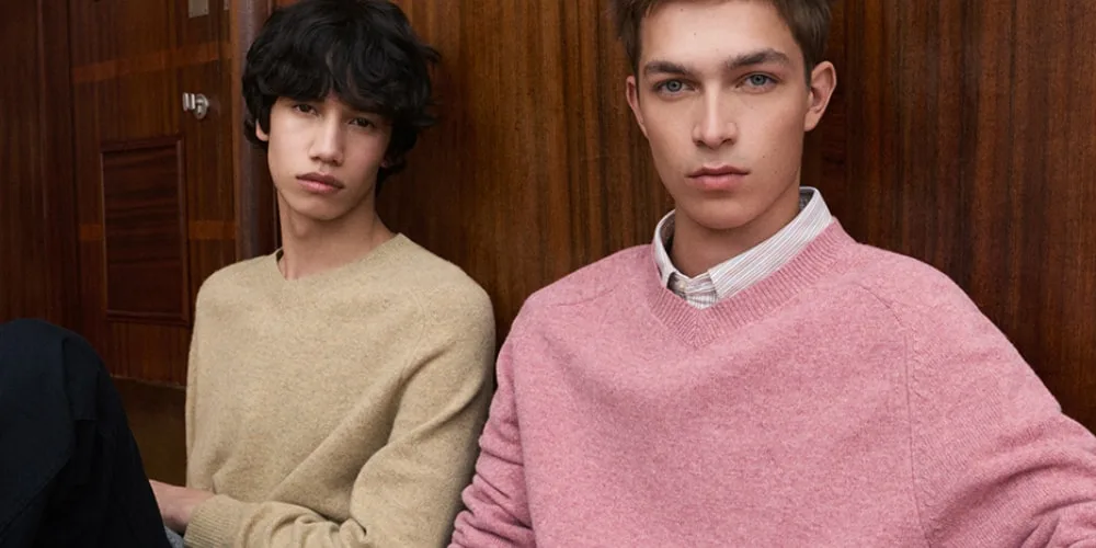 Deux hommes en pulls pastel, décor en bois