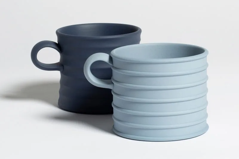 Deux tasses en céramique bleues avec des anses.