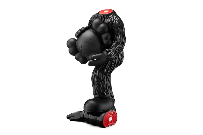 Sculpture noire avec des détails rouges et X sur la tête.