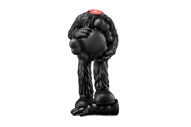 Sculpture noire sans tête tenant une boule.