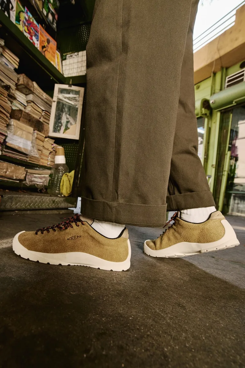 Personne portant des chaussures marron avec un pantalon vert.