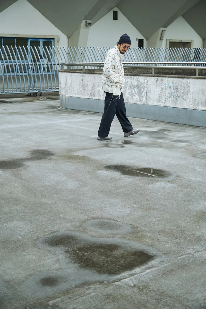 Personne marchant sur une terrasse humide avec des flaques d'eau.