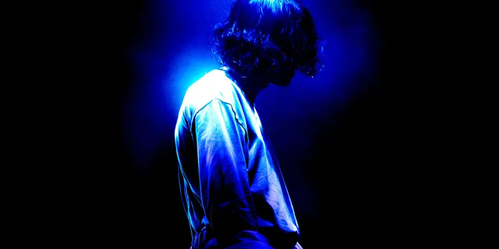 Silhouette d’une personne éclairée par une lumière bleue dans l’obscurité