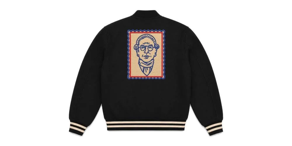 Veste noire avec illustration de visage au dos, bordures contrastées.