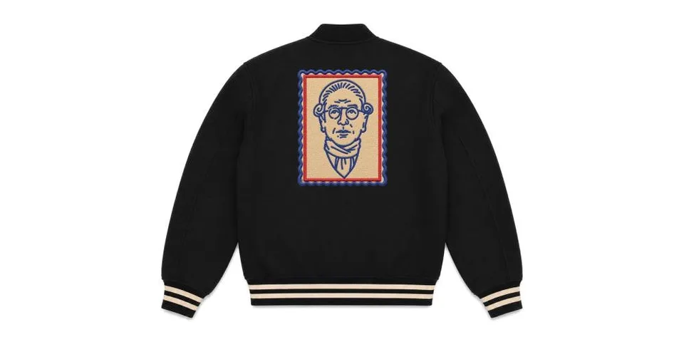 Veste noire avec illustration de visage au dos, bordures contrastées.