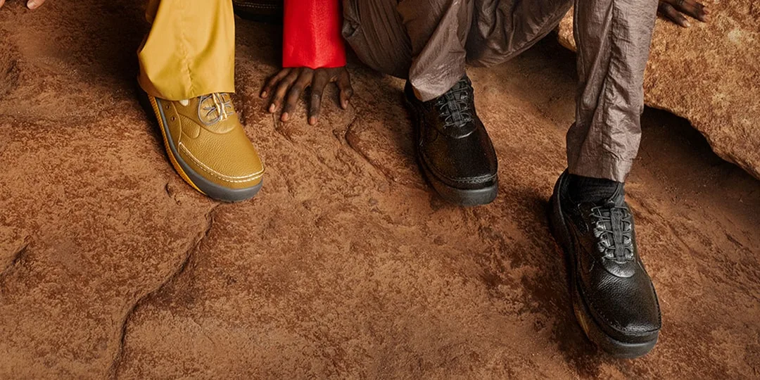 Deux personnes portant des chaussures sur un sol rocheux.