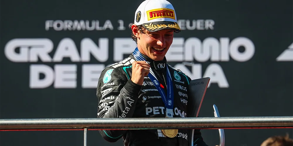 Pilote F1 célèbre sur le podium avec médaille et trophée.