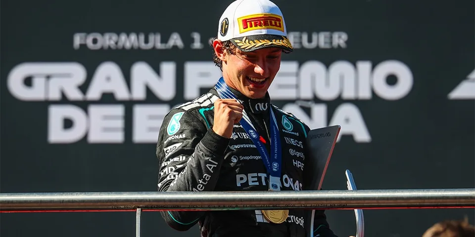 Pilote F1 célèbre sur le podium avec médaille et trophée.