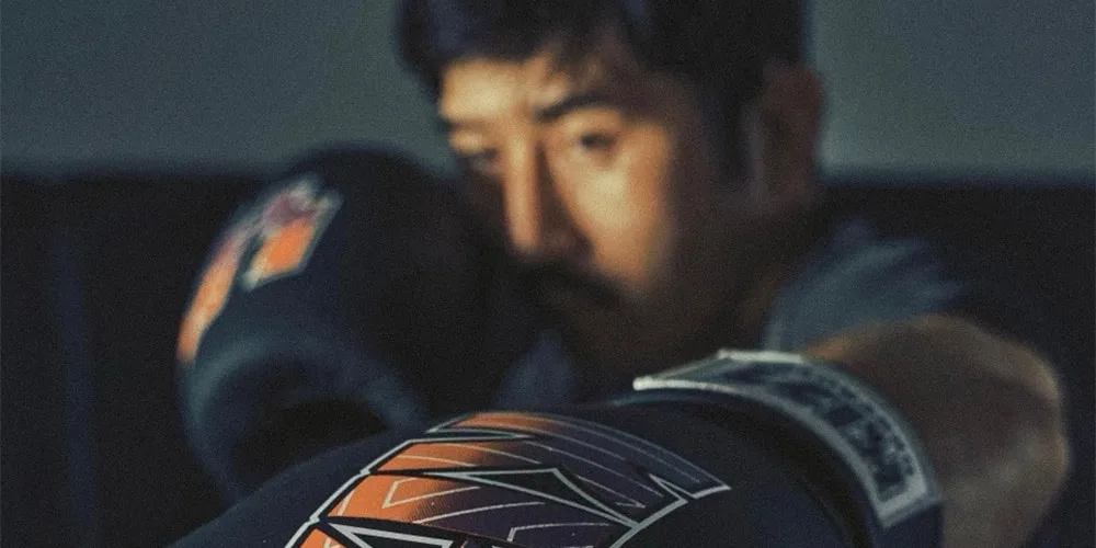 Homme boxeur concentré avec des gants noirs et orange