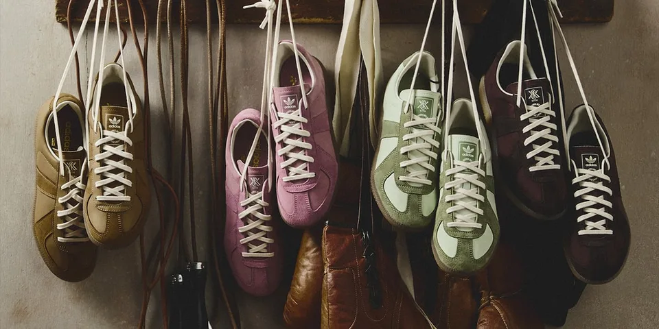 Chaussures colorées suspendues par leurs lacets contre un mur.