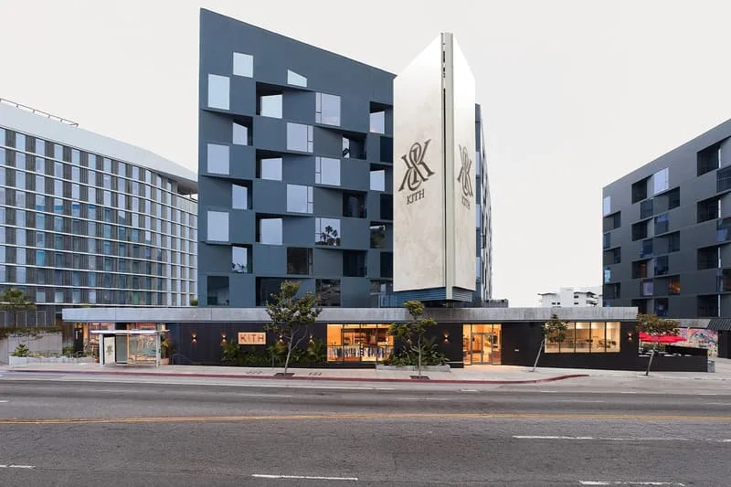 Bâtiment moderne avec vitrines sur rue, grandes formes géométriques.