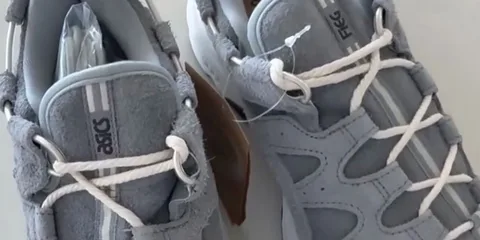 Des baskets grises Asics avec des lacets blancs.