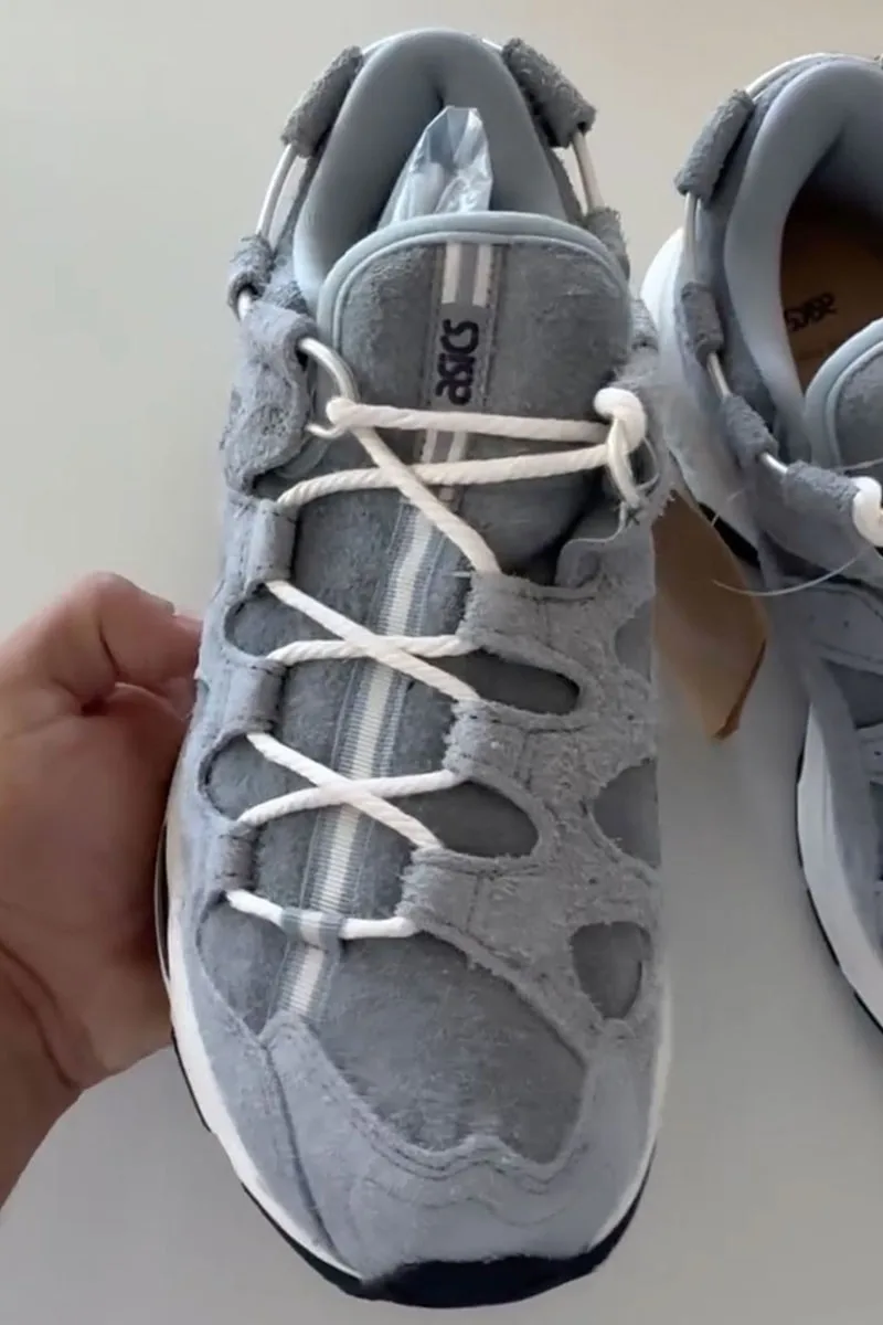 Chaussures de sport grises avec lacets blancs.