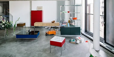 Salon moderne avec meubles colorés et objets décoratifs, éclairage naturel.