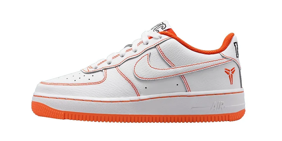 Chaussure de sport blanche avec accents orange et logo Nike, vue de côté gauche.