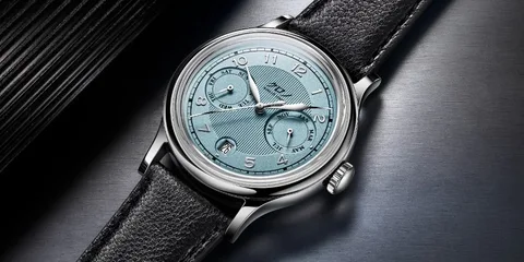 Montre classique avec un cadran bleu clair et bracelet en cuir noir.