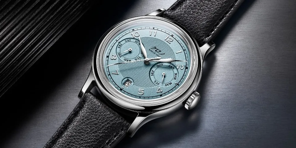 Montre classique avec un cadran bleu clair et bracelet en cuir noir.