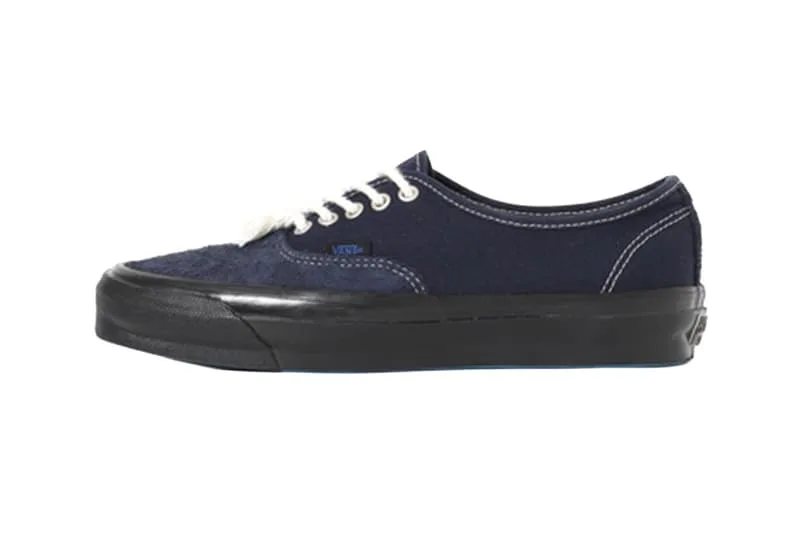 Chaussure en toile bleue avec semelle noire et lacets blancs.