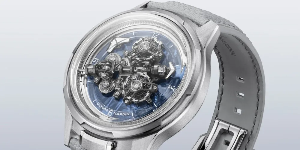 Montre argentée avec mécanisme visible et bracelet en cuir gris