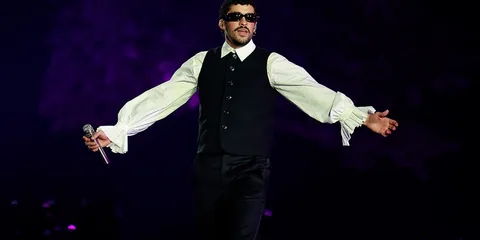 Personne en concert avec micro et tenue élégante, fond violet.