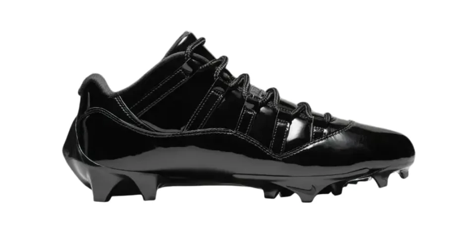Chaussure à crampons noire avec lacets, design sportif et élégant.